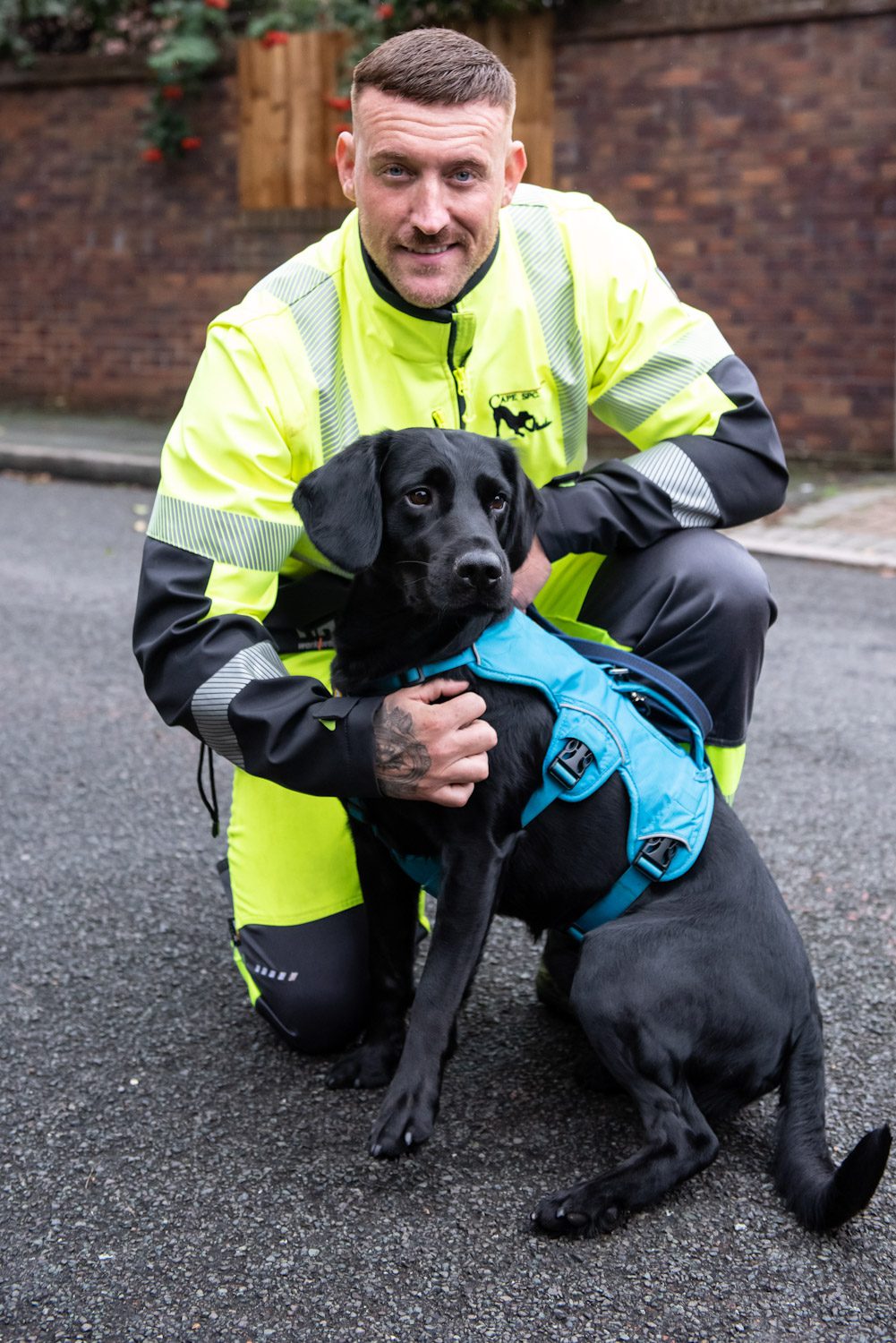 Handler with black labrador cross